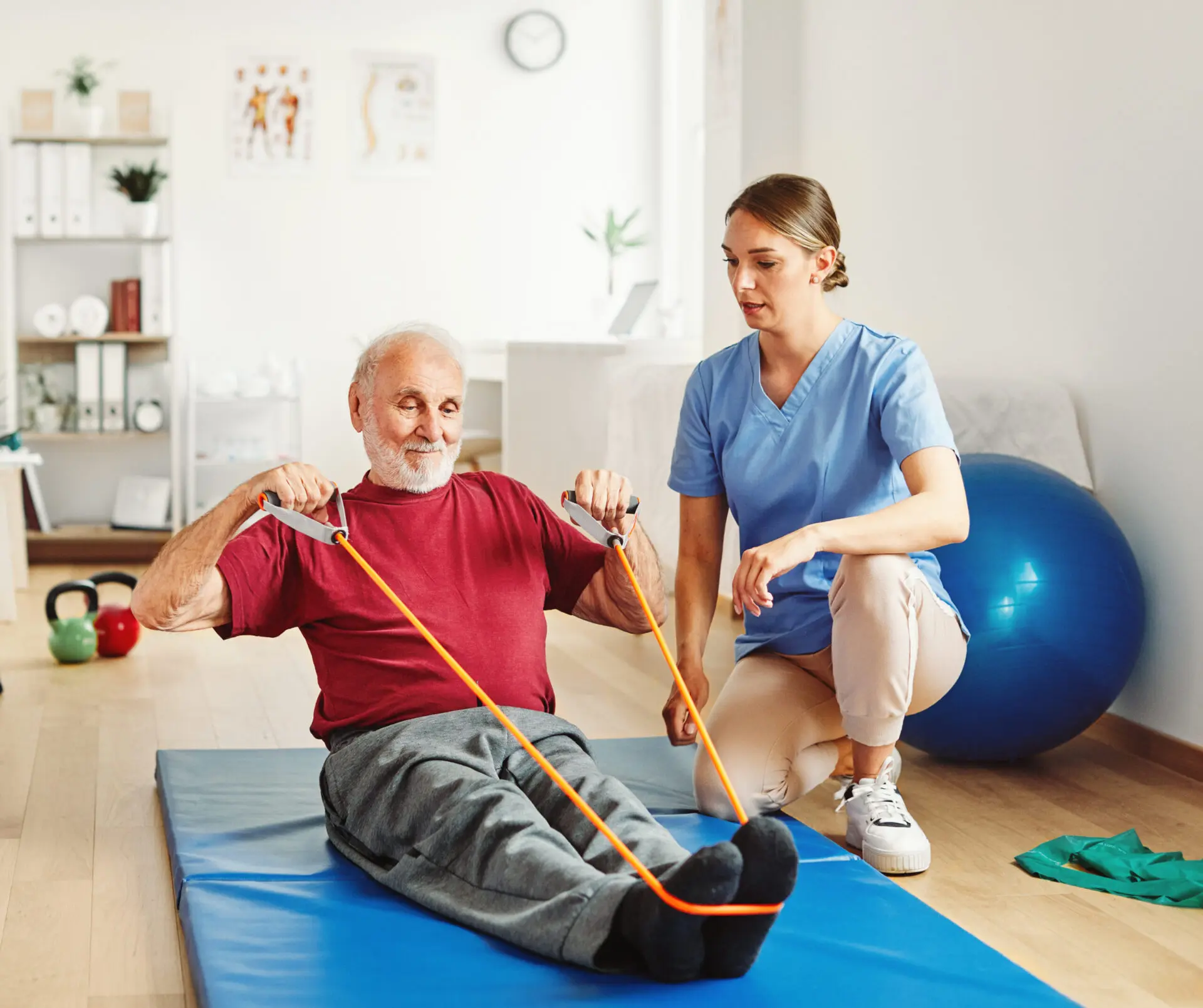 Doctor or nurse caregiver exercise with senior man at clinic or nursing home