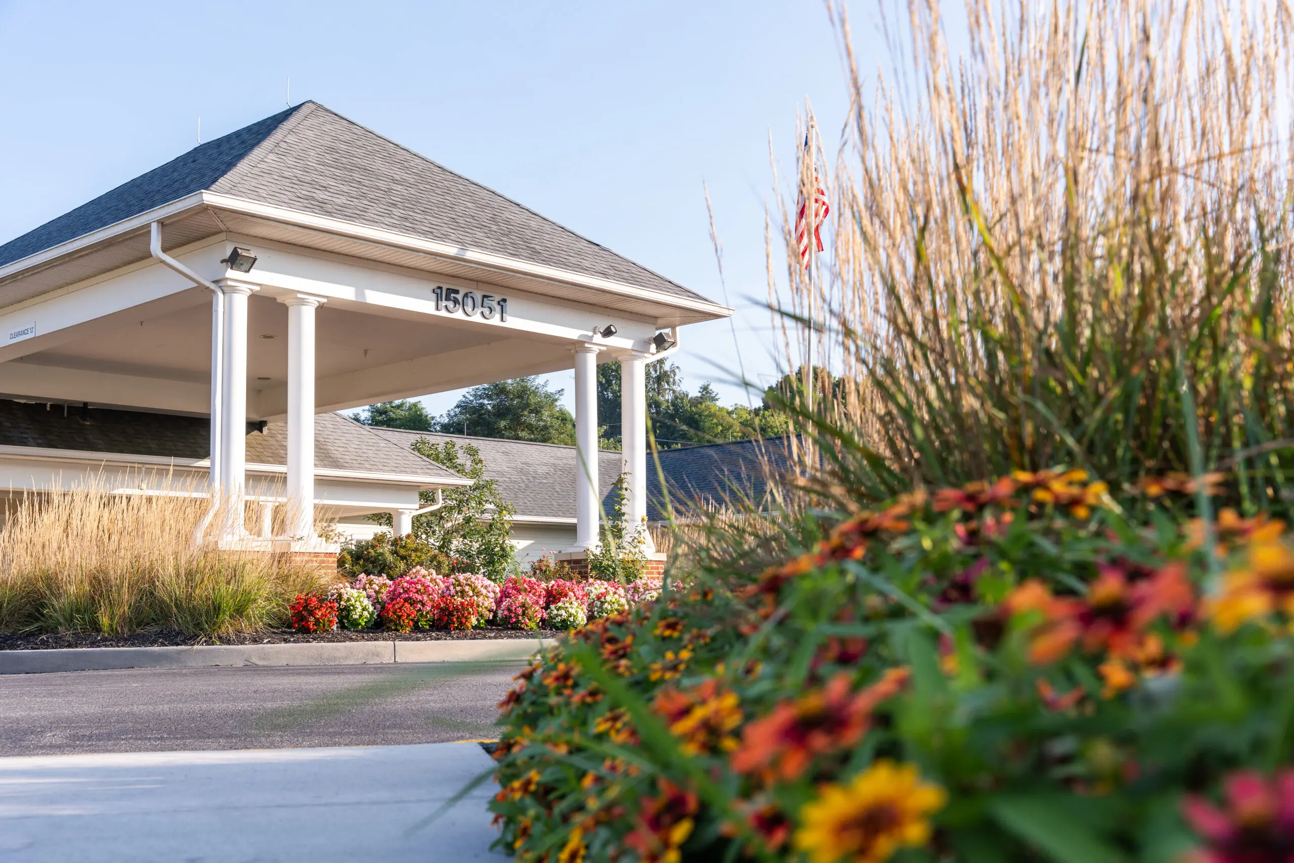 Exterior photo of the Abingdon Health & Rehab Center covered entryway, numbered 15051 and shot through foliage