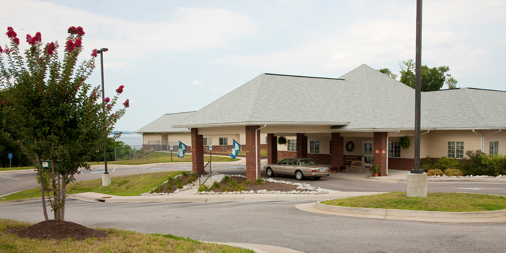 Exterior shot of a beige and brick building and parking area