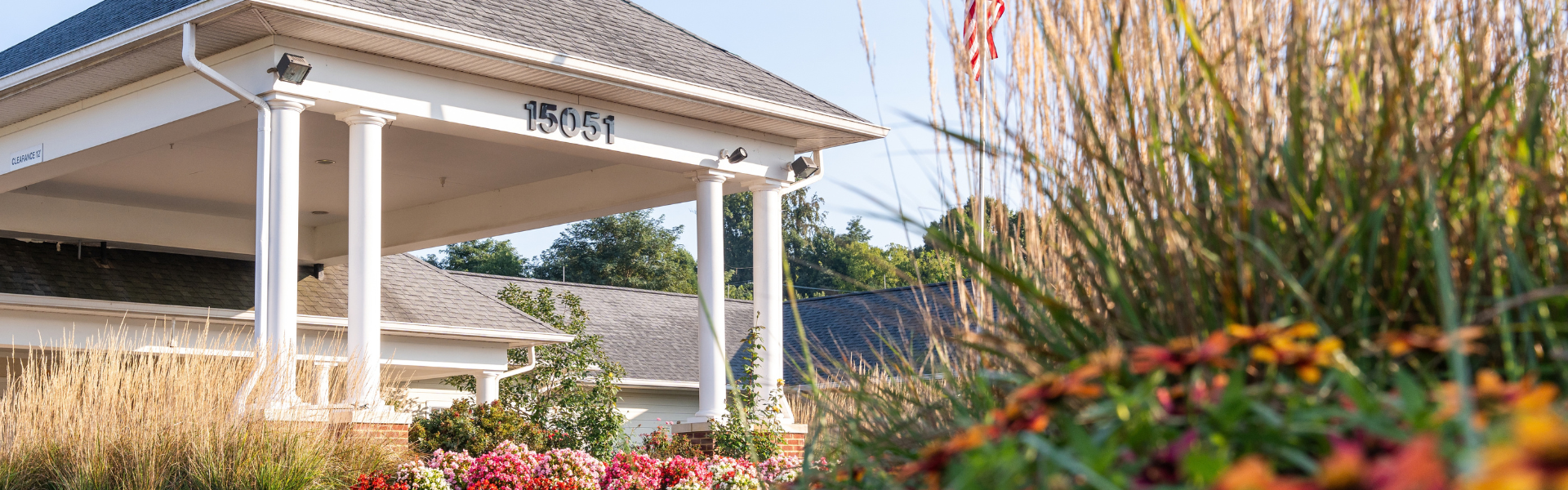 Exterior photo of the Abingdon Health & Rehab Center covered entryway, numbered 15051 and shot through foliage